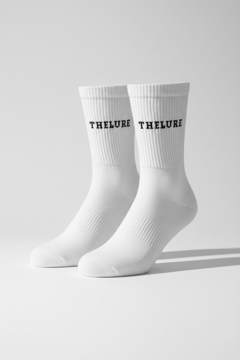 Weisse thelureclothing Performance-Socken mit schwarzem Logo-Schriftzug und rutschfester Grip-Sohle für sicheren Halt.